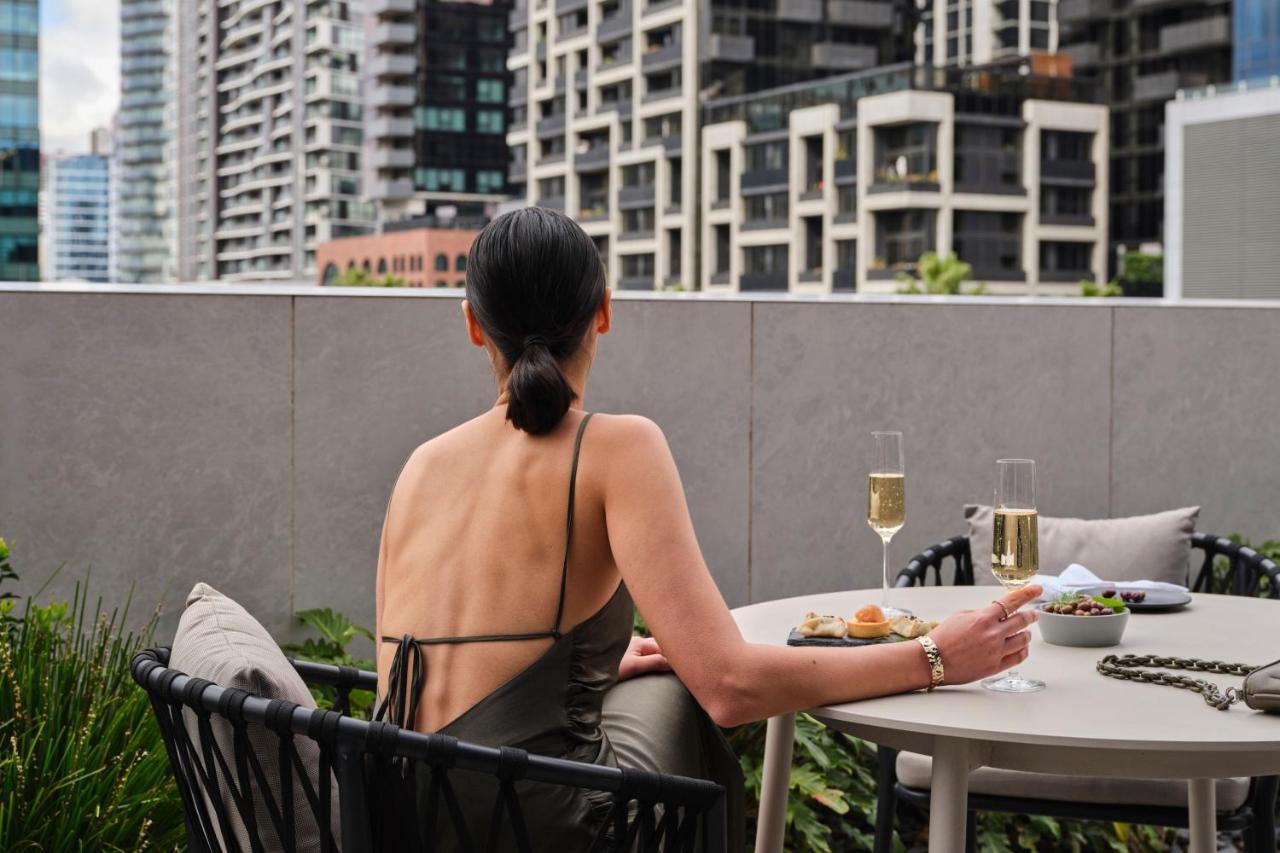 Melbourne Marriott Hotel Docklands Kültér fotó A woman sitting on a balcony